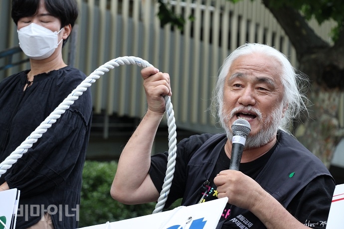 박경석 전국장애인야학협의회 이사장이 장애인을 옥죄는 장애등급제, 부양의무자기준, 거주시설을 설명하며, 밧줄을 들어 보이고 있다. 사진 강혜민