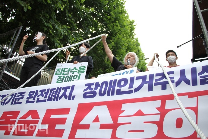 전국에서 1000여 명의 장애인활동가들이 서울지방조달청 앞으로 집결했다. 사람들이 장애인을 옥죄는 장애등급제, 부양의무자기준, 거주시설을 의미하는 밧줄을 들어 보이고 있다. 사진 강혜민