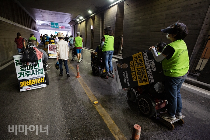 장애인활동가들이 반포지하차도를 건너는 모습. 전동 휠체어 뒤에 비장애인 활동가가 올라타 행진에 함께하고 있다. 사진 박승원