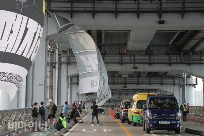 잠수교에 도착한 장애인 활동가들은 다리에 ‘장애등급제 진짜 폐지하라’ ‘부양의무자 기준 완전 폐지하라’ ‘장애인거주시설 폐쇄법 제정하라’ 등 현수막을 내걸었다. 사진 강혜민