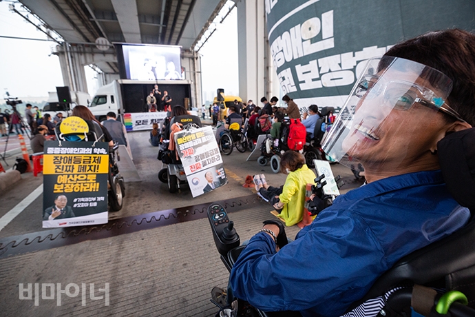 무대를 보던 김기호(51) 활동가가 잠수교에서 진행하는 문화행사를 지켜보다가 활짝 웃어 보였다. 그는 “장애등급제 폐지가 됐다는데... 뭐가 바뀌었는지 모르겠다. 답답해서 일산에서 여기까지 찾아왔다”라고 밝혔다. 사진 박승원