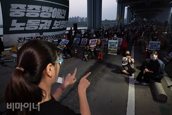 이현정 수어통역사가 청중을 향해 수어통역하는 모습. 그 앞에는 박미애 수어통역사가 미러(mirror) 통역을 하고 있다. 무대에서 수어통역을 할 때에는 스피커 소리가 너무 커서 말하는 사람 목소리가 잘 들리지 않는다. 그렇기에 동료 수어통역사가 말을 대신 전달해 준다. 맨 오른쪽에는 최지영 수어통역사가 쉬고 있다. 사진 박승원 