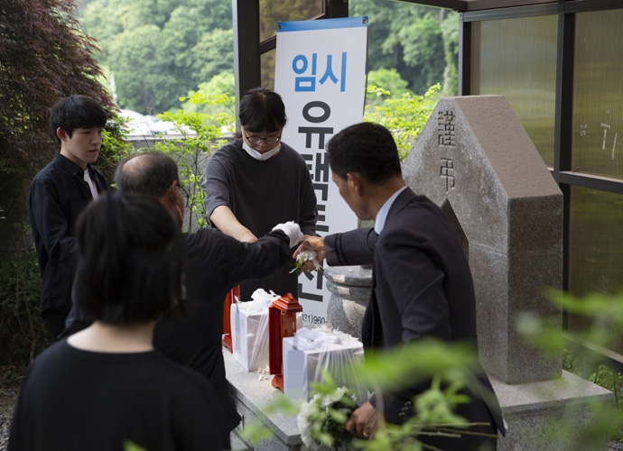 무연고 장례에서 나눔과나눔 활동가, 자원봉사자, 의전업체 직원이 산골을 진행하는 모습을 지켜보는 딸. 사진 나눔과나눔 무연고 장례에서 나눔과나눔 활동가, 자원봉사자, 의전업체 직원이 산골을 진행하는 모습을 지켜보는 딸. 사진 나눔과나눔