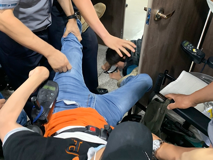 문애린 서울장애인차별철폐연대 활동가가 시장실 안에 들어가서 문을 닫지 못하게 막고 있다. 한 활동가는 끌려나오고 있다. 사진 경기장애인차별철폐연대