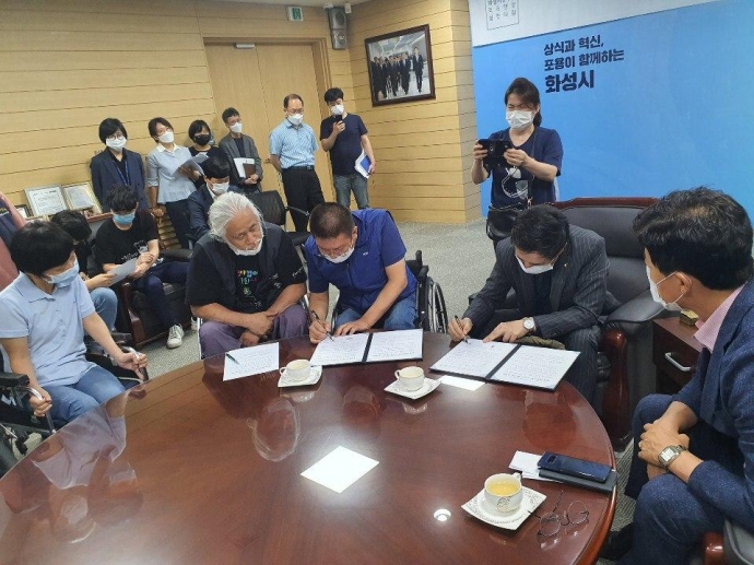 23일, 서철모 화성시장과 권달주 경기장차연 상임대표가 합의문에 서명을 하고 있다. 사진제공 경기장차연