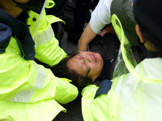 이형숙 서울장애인자립생활센터협의회 회장이 경찰에 진압되어 도로위에서 얼굴을 찡그리고 있다. 사진 이가연 이형숙 서울장애인자립생활센터협의회 회장이 경찰에 진압되어 도로위에서 얼굴을 찡그리고 있다. 사진 이가연