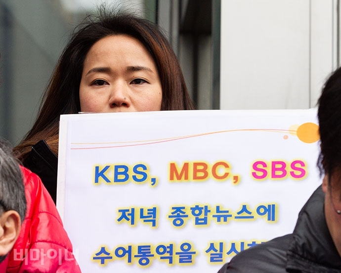 지난 2019년 2월 20일 농인들이 수화언어 시청권을 보장하지 않는 방송통신위원회, KBS·MBC·SBS 등 공영방송 3곳을 국가인권위원회에 진정했다. 한 참가자가 “KBS, MBC, SBS 저녁 종합뉴스에 수어통역을 실시하라”라고 적힌 손팻말을 들고 있다. 사진 박승원
