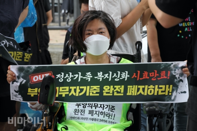 권은춘 충북장애인차별철폐연대(아래 충북장차연) 대표가 삭발을 하기 전, 단발머리를 하고 피켓을 들고 있다. 사진 이가연