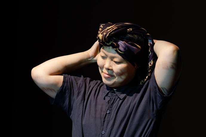 시민연극 「아파도 미안하지 않습니다」의 한 장면. 한 사람이 머리에 두건을 두른 채 두 손으로 머리 뒤쪽을 만지고 있다. 사진 김덕중 시민연극 「아파도 미안하지 않습니다」의 한 장면. 한 사람이 머리에 두건을 두른 채 두 손으로 머리 뒤쪽을 만지고 있다. 사진 김덕중