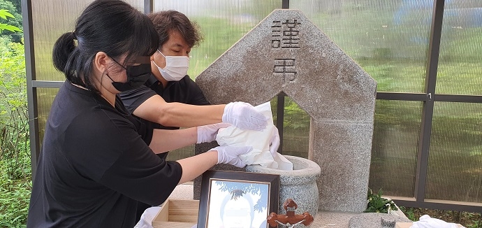 어머니를 간호하느라 자신의 몸을 돌보지 못했던 무연고사망자의 장례에 참석한 지인이 서울시립승화원 유택동산에서 유골을 뿌리고 있다. 사진 나눔과나눔