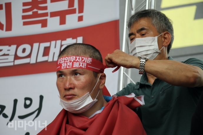 10일, 중앙생활보장위원회 회의가 열리는 세종시 보건복지부 앞에서 기초법바로세우기공동행동 등의 주최로 6명의 장애인들이 부양의무자기준 완전 폐지 약속 이행을 요구하며 삭발투쟁 결의대회를 열었다. 추경진 서울장애인차별철폐연대 개인대의원이 삭발을 하고 머리에 ‘부양의무자기준 완전폐지’라고 적힌 띠를 두르고 있다. 사진 이가연 10일, 중앙생활보장위원회 회의가 열리는 세종시 보건복지부 앞에서 기초법바로세우기공동행동 등의 주최로 6명의 장애인들이 부양의무자기준 완전 폐지 약속 이행을 요구하며 삭발투쟁 결의대회를 열었다. 추경진 서울장애인차별철폐연대 개인대의원이 삭발을 하고 머리에 ‘부양의무자기준 완전폐지’라고 적힌 띠를 두르고 있다. 사진 이가연