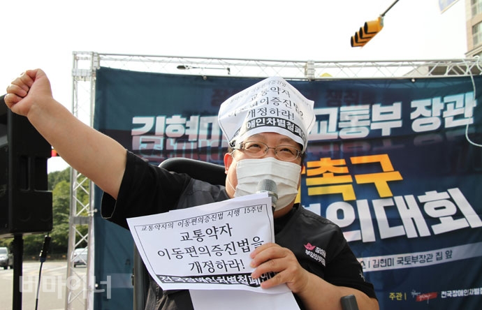 이형숙 서울시장애인자립생활센터협의회 회장이 왼손에 “교통약자 이동편의 증진법을 개정하라”고 적힌 손피켓을 들고 투쟁을 외치며 오른손을 하늘을 향해 들어 보이고 있다. 사진 강혜민 