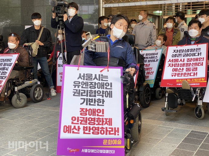 한 활동가가 ‘서울시는 유엔장애인 권리협약에 기반한 장애인 인권영화제 예산 반영하라’라고 적힌 피켓을 들고 있다. 사진 이가연