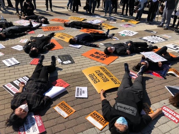 검은 옷을 입은 여성들이 바닥에 누워 있으며 그 옆에는 “안전한 임신중지 전면 비범죄화”, “우리의 임신중지를 지지하라”, “낙태죄를 폐지하라”라고 적힌 피켓들이 놓여 있다. 사진 제공 셰어