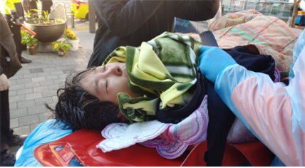 수협의 물대포를 맞은 한 상인이 들것에 누워 있다. 사진 함께살자 노량진수산시장 시민대책위원회