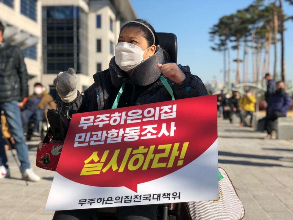 전국장애인차별철폐연대 등 3개 장애인인권단체는 2일, 전라북도청 앞에서 기자회견을 열고 전북 지역에서 발생한 장애인거주시설 범죄에 대해 전북도의 책임을 촉구했다. 한 참가자가 ‘무주 하은의집 민관합동조사 실시하라!’라는 피켓을 목에 걸고 있다. 사진 전국장애인차별철폐연대
