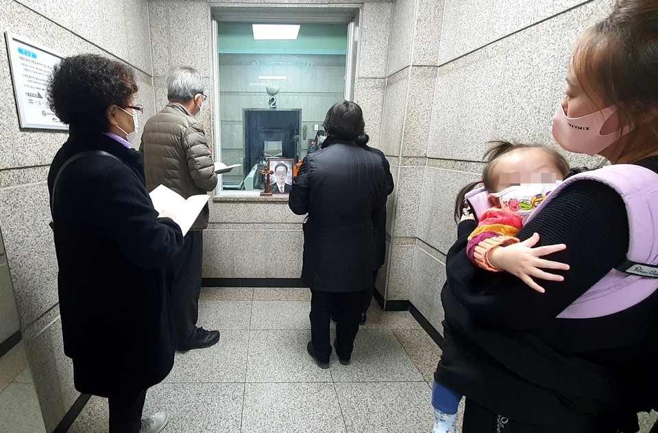 30대 초반에 사망한 조카의 무연고 장례에 참석한 이모. 아이를 안고 지방에서 올라와 조카의 관이 화로에 들어가는 모습을 보고 있다. 사진 나눔과나눔