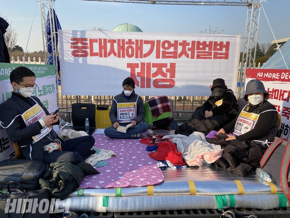 중대재해기업처벌법 제정 촉구를 위한 단식 농성 현장. 오른쪽부터 고 김동준 씨 어머니 강석경 씨, 고 김태규 씨 누나 김도현 씨, 고 김재순 씨의 아버지 김선양 씨, 그리고 손익찬 민주사회를위한변호사모임 노동위원회 변호사가 농성장에 앉아 있다. 사진 이가연 