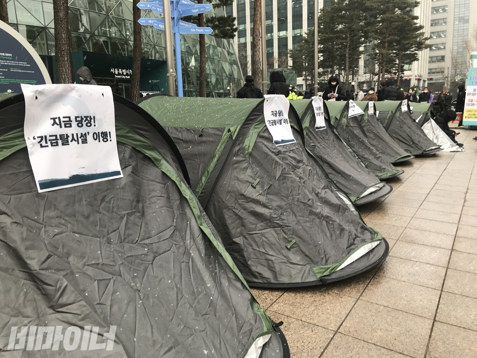 서울시청 앞에 늘어선 45개 텐트 행렬. 텐트마다 ‘지금 당장! 긴급 탈시설 이행’이라는 문구가 쓰인 종이 팻말이 붙어 있다. 사진 허현덕