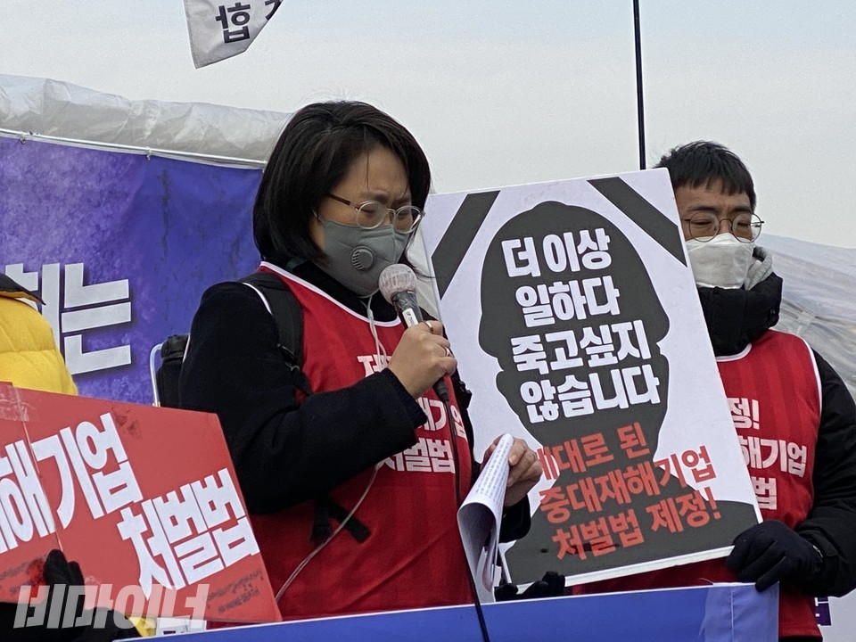 가습기살균제 피해 당사자인 조순미 가습기살균제참사피해자총연합 대표가 산소통을 메고 발언을 하고 있다. 뒤편에는 '더 이상 일하고 죽고 싶지 않습니다. 제대로 된 중대재해기업처벌법 제정!'이라고 적힌 팻말이 있다. 사진 이가연