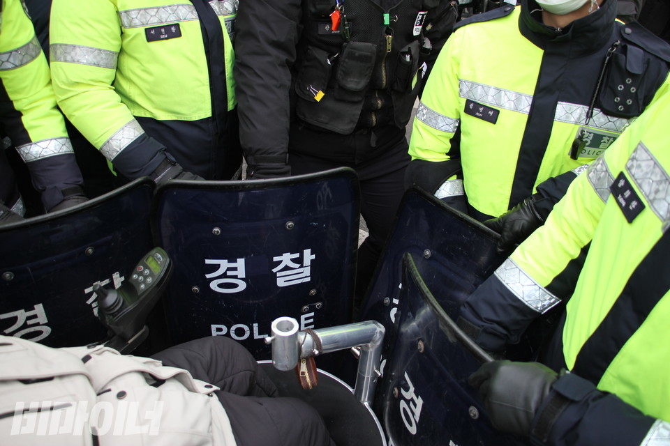 장애인 활동가의 휠체어가 경찰 방패에 의해 가로 막혔다. 사진 강혜민