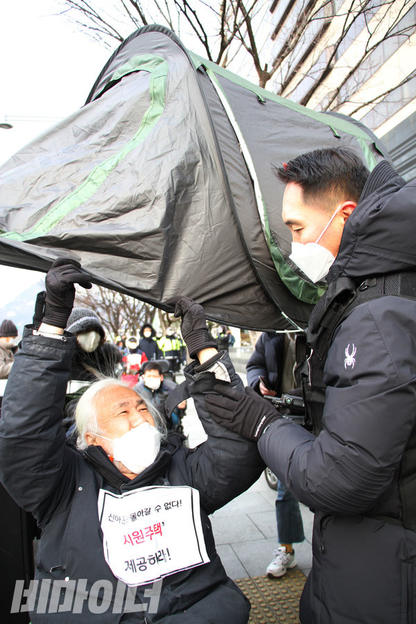 박경석 전국장애인야학협의회 이사장이 긴급 탈시설을 상징하는 1인용 텐트를 펼치고 이동하려고 하자 경찰에게 저지당했다. 경찰이 텐트를 빼앗으려고 하자 텐트를 붙잡으며 저항하고 있다. 사진 강혜민