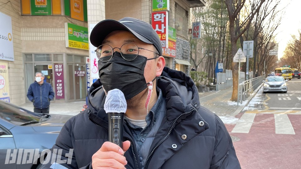 정민구 장애와인권발바닥행동 활동가가 기자회견에서 발언하고 있다. 까만색 모자와 마스크, 안경을 썼다. 사진 하민지