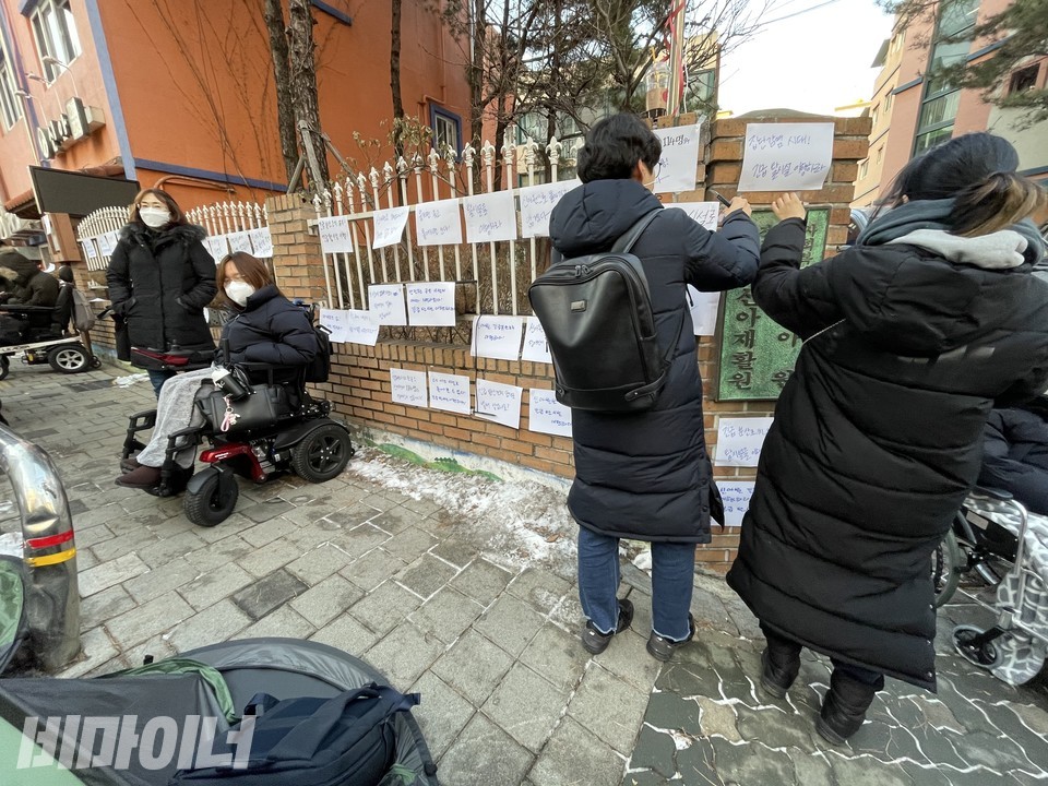 활동가들이 신아원 현판 주변에 피켓을 붙이고 있다. 사진 하민지
