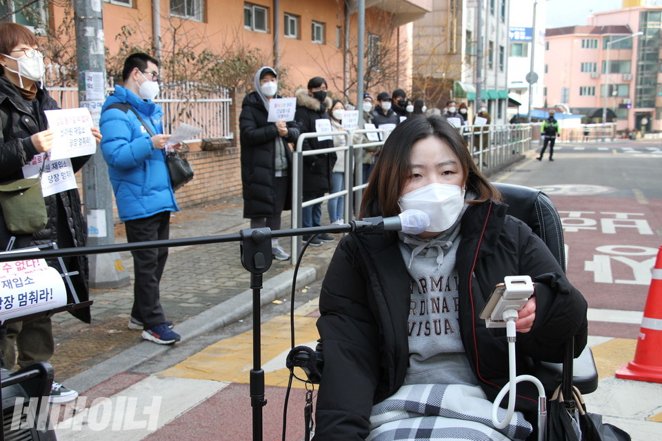 진은선 장애여성공감 부설 장애여성독립생활센터[숨] 팀장이 발언하고 있다. 그 뒤로는 기자회견 참가자들이 사회적 거리두기를 하며 참가하는 모습이 보인다. 사진 허현덕