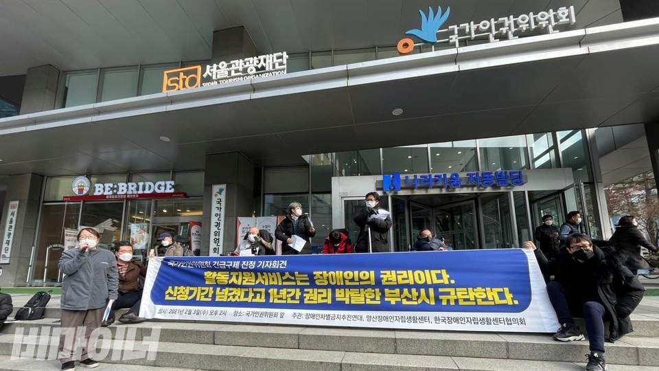 장애인운동단체들이 인권위 건물 앞에서 기자회견을 열고있다. 현수막에는 '활동지원서비스는 장애인의 권리이다. 신청기간 넘겼다고 1년간 권리 박탈한 부산시 규탄한다'라고 적혀있다. 사진 하민지