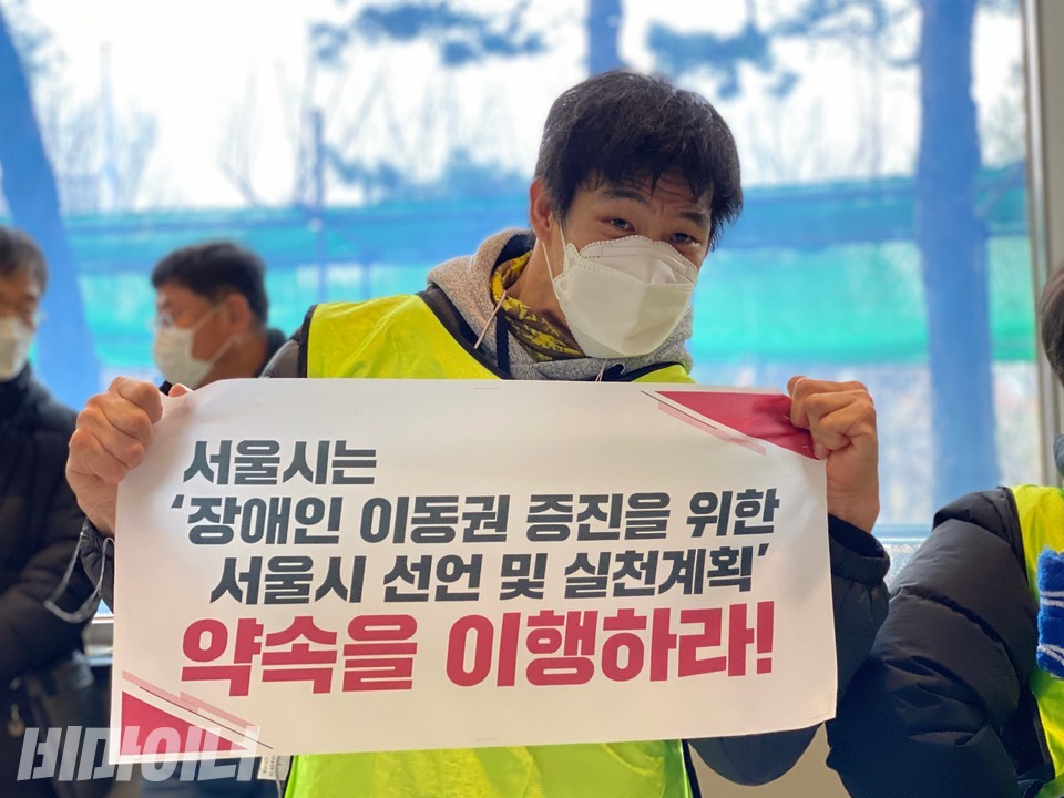 한 장애인활동가가 '서울시는 장애인이동권 증진을 위한 서울시 선언 및 실천계획 약속을 이행하라!'라고 적힌 피켓을 들고 있다. 사진 이가연