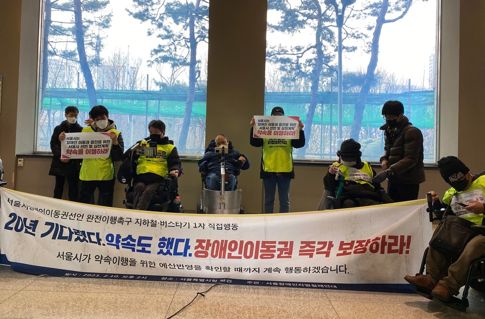 장애인 활동가들이 서울시청 별관을 점거해 기자회견을 열고 있다. 사진 이가연