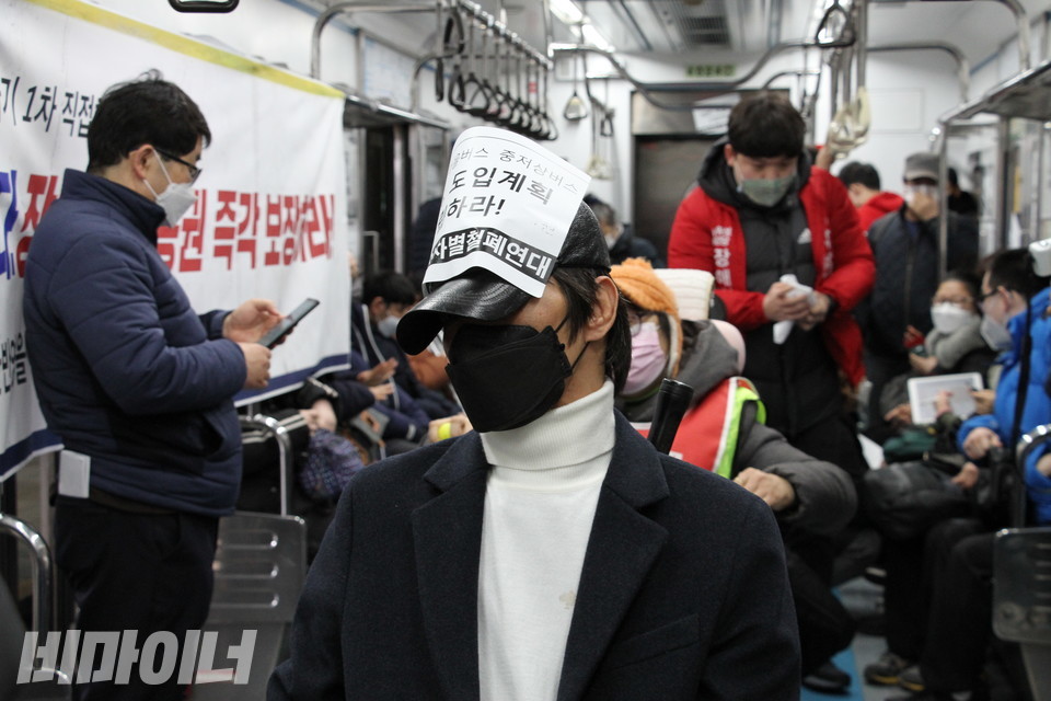 한 활동가가 자신의 모자 위에 피켓을 붙였다. 사진 하민지