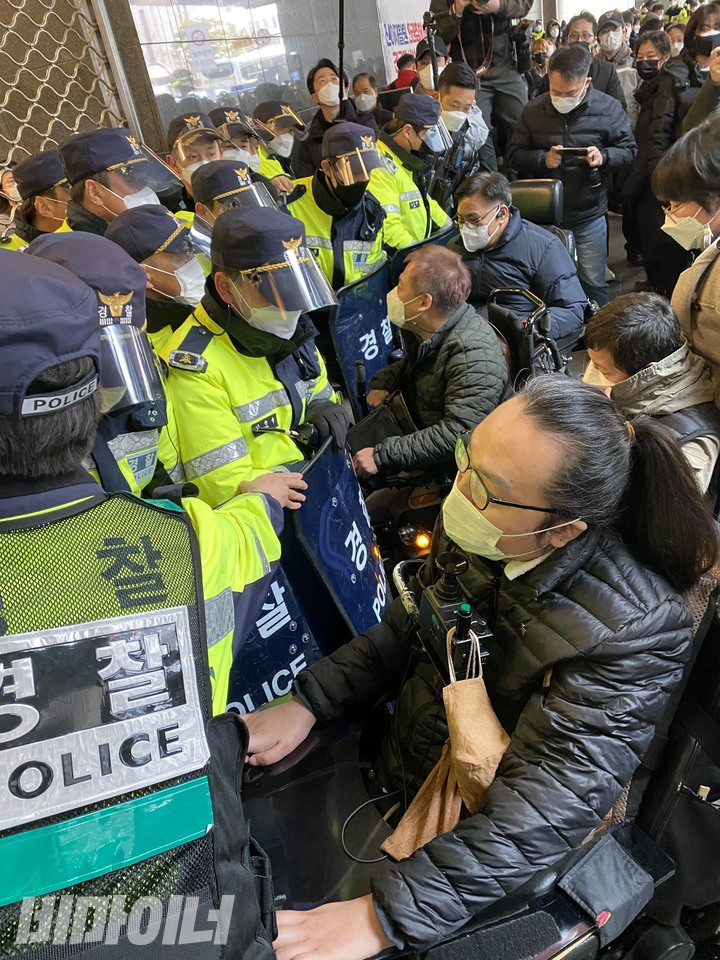 장애인 활동가들이 서울시청 후문 앞에서 경찰과 대치하고 있다. 사진 이가연
