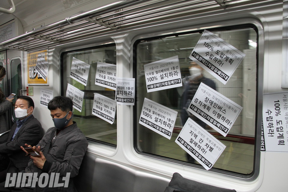 활동가들은 열차 안 곳곳에 피켓을 붙였다. 피켓에는 '장애인버스 증차계획 이행하라', '지역 간 차별 철폐하라', '서울시는 마을버스, 중저상버스 100% 도입계획 수립하라', '서울시는 2022년까지 지하철 엘리베이터 1동선 100% 설치하라' 등의 문구가 쓰여있다. 사진 하민지