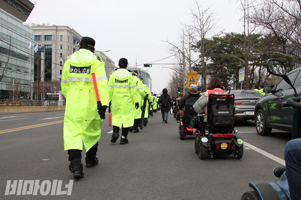 경찰 수백 명이 활동가들을 둘러싸고 있다. 휠체어를 이용하는 활동가들은 줄지어서 오세훈 후보 선거사무소로 향했다. 사진 하민지