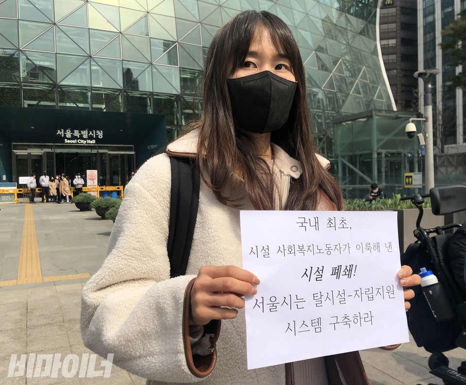 강자영 도란도란 자립지원팀장이 “국내 최초 시설 사회복지노동자가 이룩해 낸 시설 폐쇄! 서울시는 탈시설-자립지원 시스템 구축하라”고 적힌 손피켓을 들고 있다. 사진 강혜민