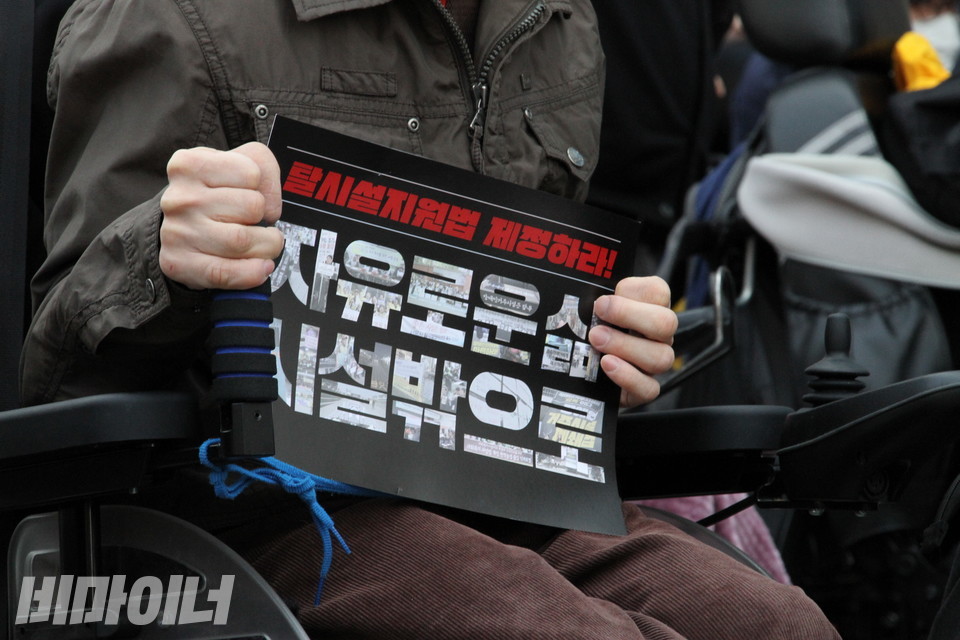 한 참가자가 ‘자유로운 삶 시설 밖으로’라는 손팻말을 들고 있다. 사진 허현덕