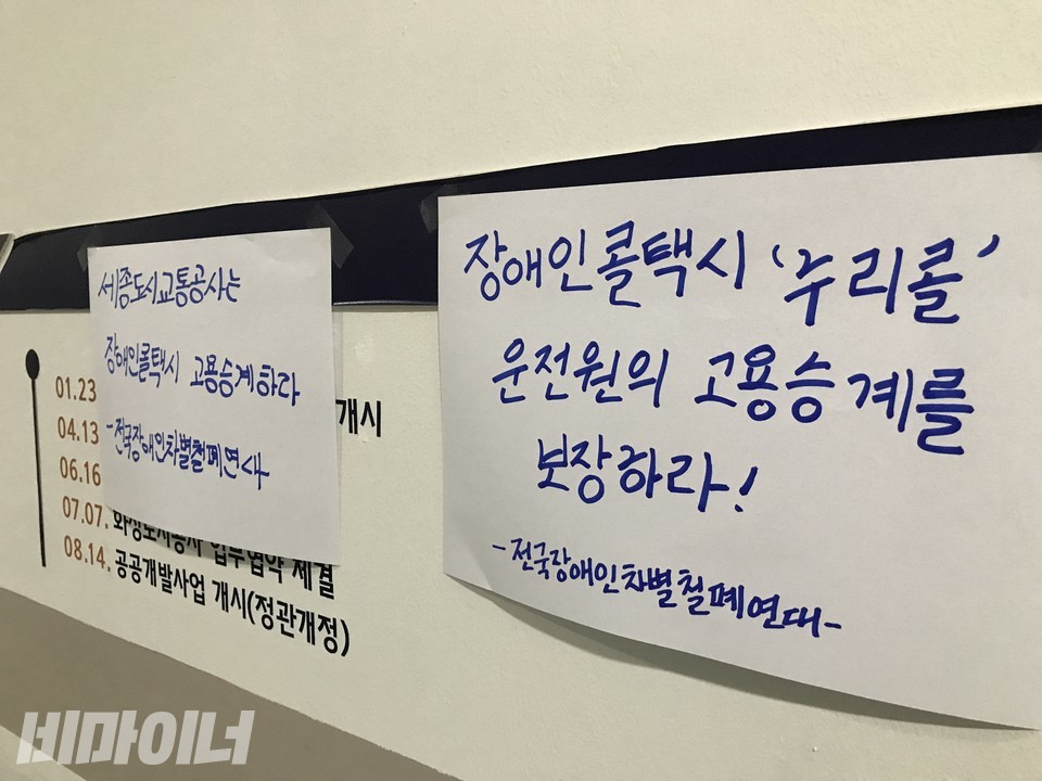 2층 사장실 복도 길목에 붙은 스티커. ‘장애인콜택시 누리콜 운전원의 고용승계를 보장하라!’라고 써 있다. 사진 허현덕