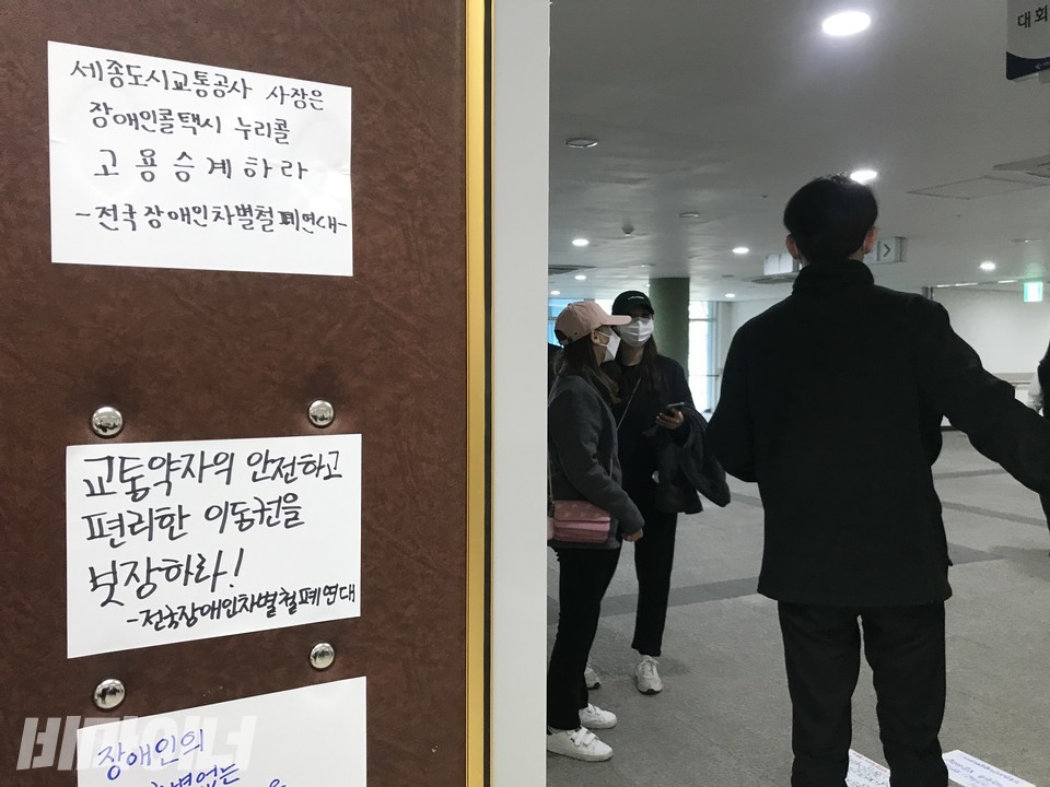 2층 대회의실에 붙은 고용승계를 촉구하는 스티커. ‘세종도시교통공사 사장은 장애인콜택시 누리콜 고용승계하라’, ‘교통약자의 안전하고 편리한 이동권을 보장하라!’ 등의 문구가 써 있다. 사진 허현덕