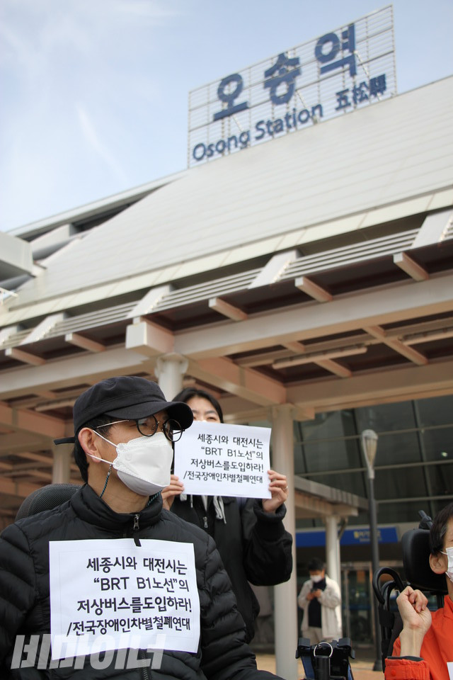 오송역 앞에 모인 장애인 활동가들. 손피켓에는 “세종시와 대전시는 BRT B1노선의 저상버스를 도입하라”고 쓰여 있다. 사진 강혜민