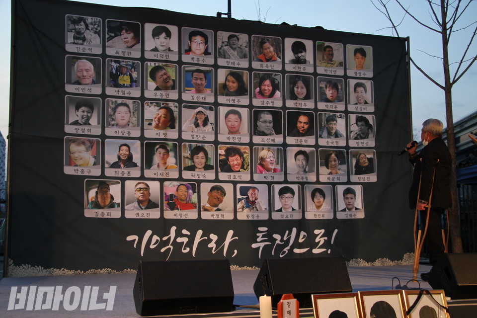 김종환 씨가 장애해방열사의 얼굴이 새겨진 현수막을 향해 노래를 부르고 있다. 사진 이가연