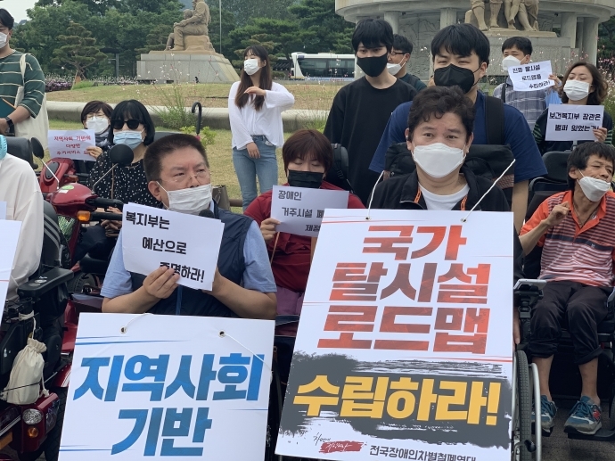장애인 활동가들이 “국가 탈시설 로드맵 수립하라”라는 피켓을 들고 있다. 사진 제공 전국장애인차별철폐연대