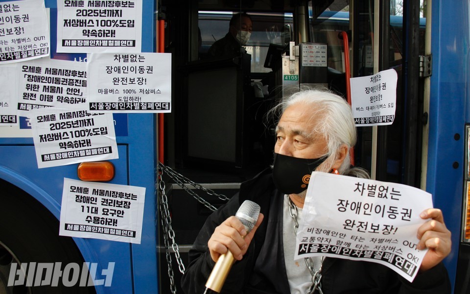 박경석 이사장이 버스와 자신의 몸을 쇠사슬로 묶었다. 박 이사장은 오세훈 후보를 향해 차별없는 장애인 이동권을 완전히 보장하라고 촉구했다. 사진 하민지