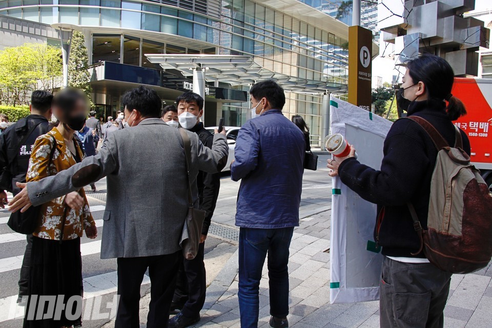소유주대책위 측 사람이 ‘공공주택사업을 중단없이 추진하라’고 외치는 활동가를 향해 “동자동 주민이세요? 자격도 없는 사람이 왜 와서 그래요? 자격 없어요!”라고 말하고 있다. 사진 이가연