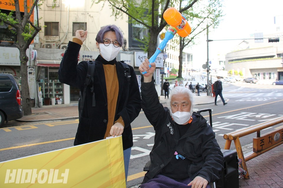 박경석 전장연 상임대표가 뿅망치를 들고 있고, 민주노총 활동가가 투쟁을 외치고 있다. 사진 이가연