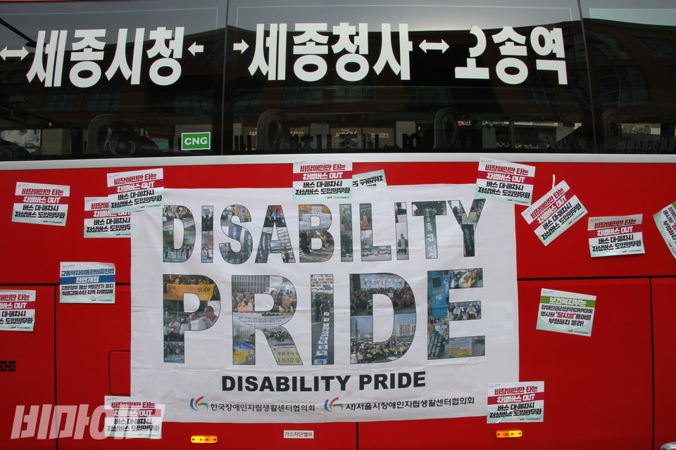 활동가들은 ‘DISABILITY PRIDE(장애 자긍심)’이라고 적힌 현수막을 B1 버스에 붙였다. 사진 강혜민