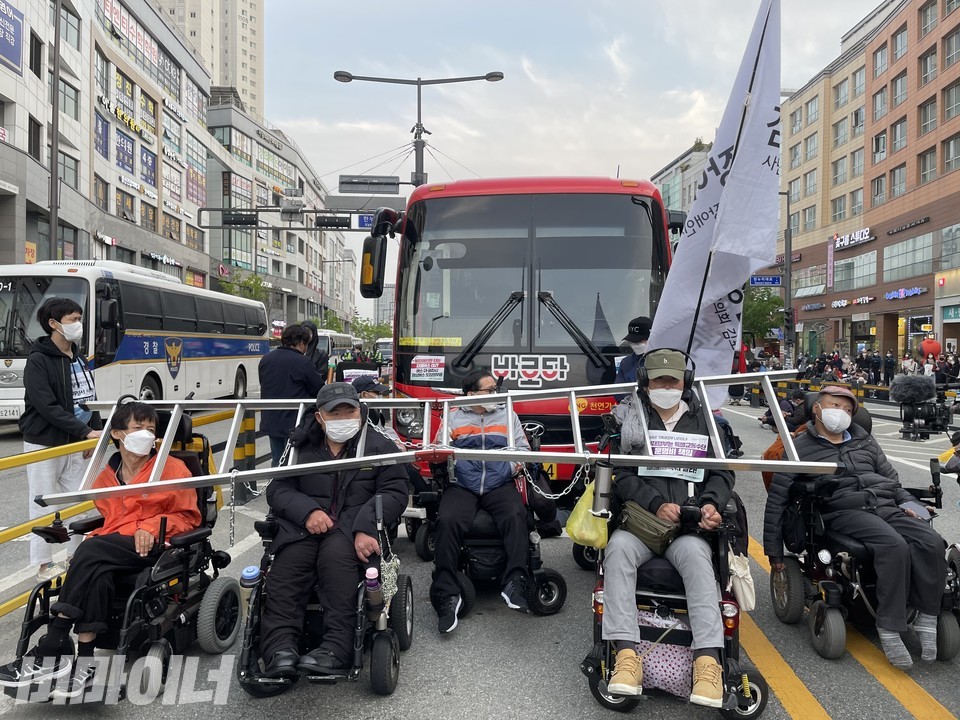 휠체어를 이용하는 장애인 활동가들은 사다리를 목에 걸고 B1 버스를 점거했다. 사진 하민지