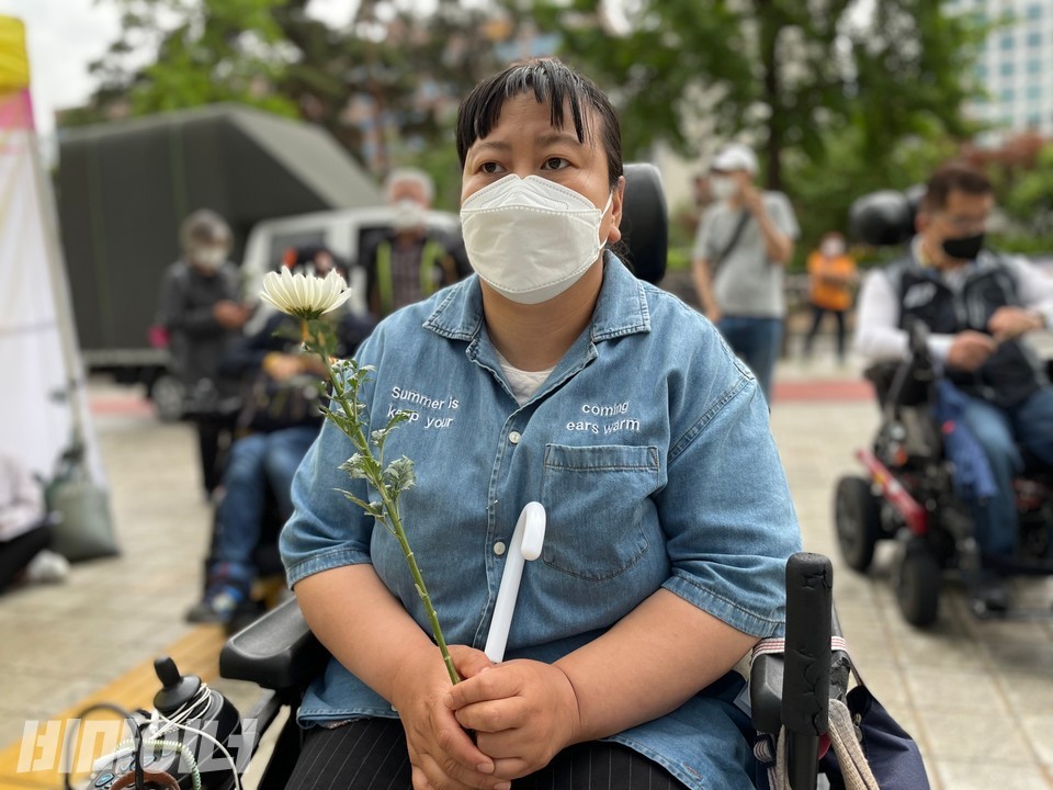 추모제에 참가한 한 활동가가 국화 한 송이를 손에 들고 있다. 사진 하민지