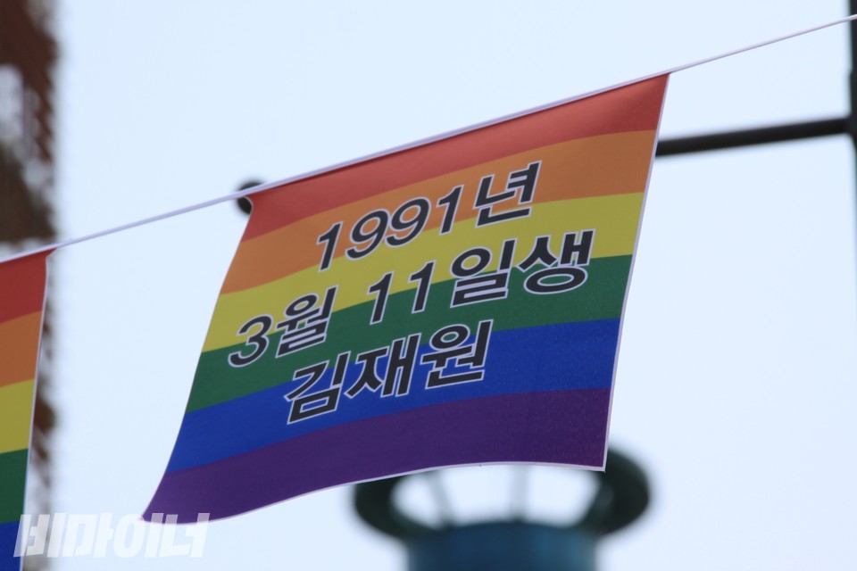 무지개 플래그에 ‘1991년 3월 11일생 김재원’이라 적혀 있다. 사진 하민지